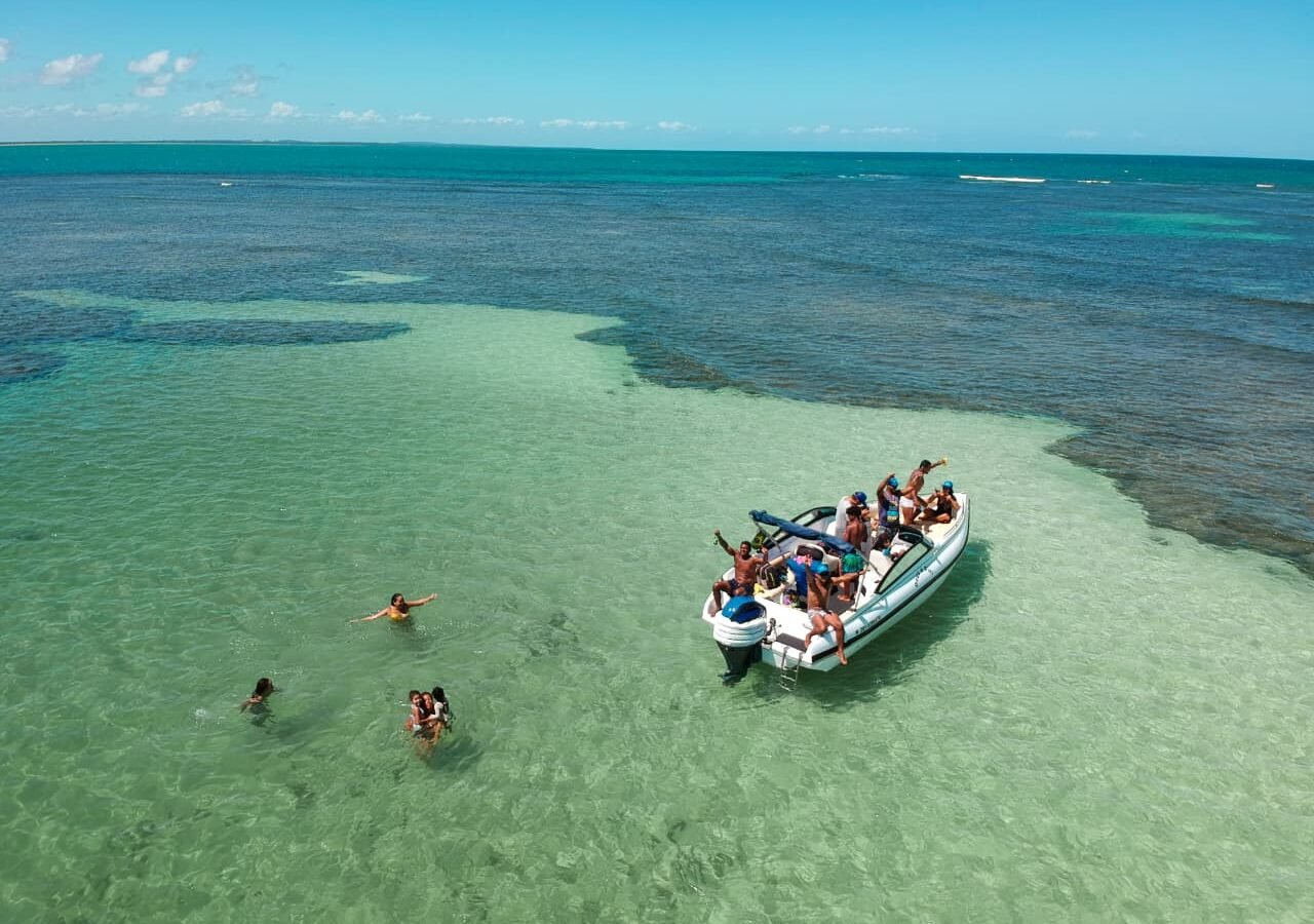 Lancha da La Barca ancorada em banco de areia de água transparente em Morro de São Paulo